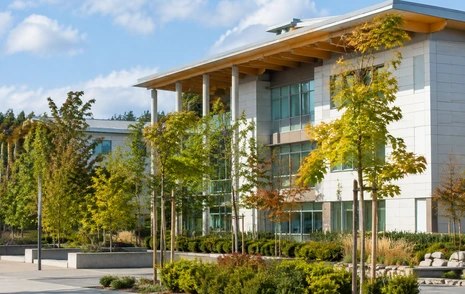 A modern college campus building with a landscaped forecourt in Surrey BC
