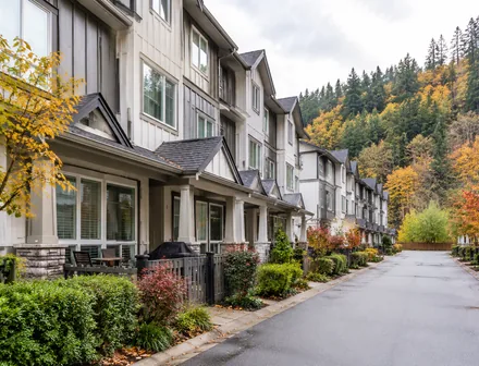 A row of newer townhomes against a treed hillside, townhomes for sale in East Abbotsford