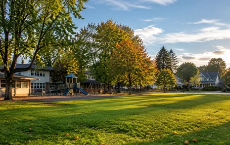 A school field framed by mature trees in a small village in Langley, BC
