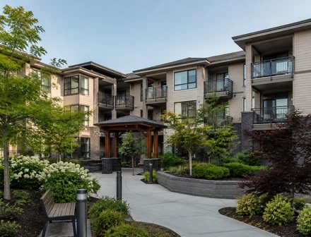 A four storey wood frame condo building with glass balconies, condos for sale in Guildford, Surrey BC