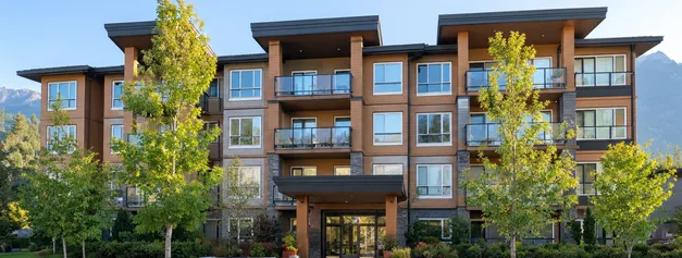 A 4 storey condo building with balconies and street trees, condos and apartments for sale in Maple Ridge BC