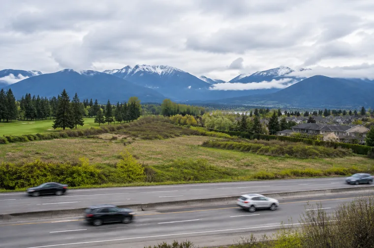 Open land beside the Lougheed Highway in Pitt Meadows with the mountains to the north