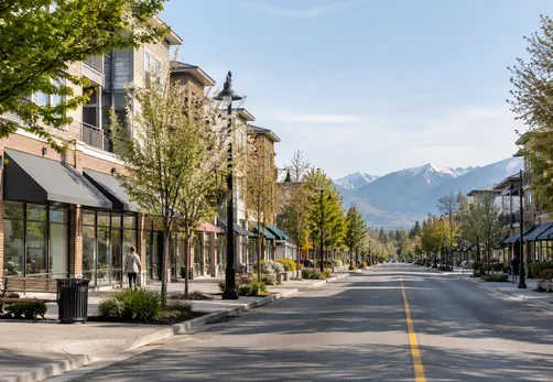 Low rise homes and shops along a tree lined main street in the Pitt Meadows Town Centre
