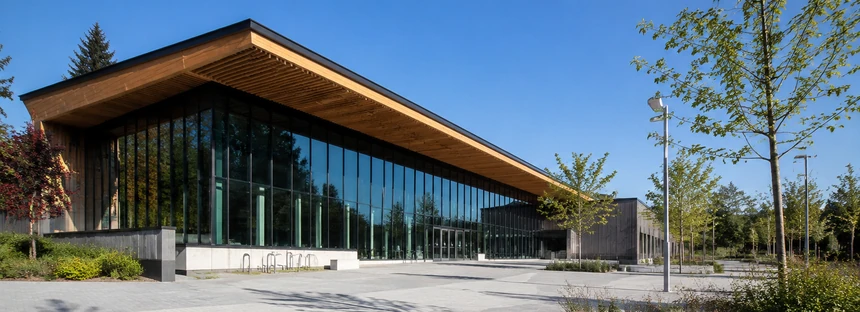 A modern community recreation centre with glass frontage and a landscaped plaza in Surrey BC
