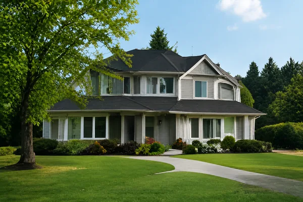 A large detached house set back on a wide lawn with conifers behind, houses for sale in Brookswood and Fernridge, Langley BC